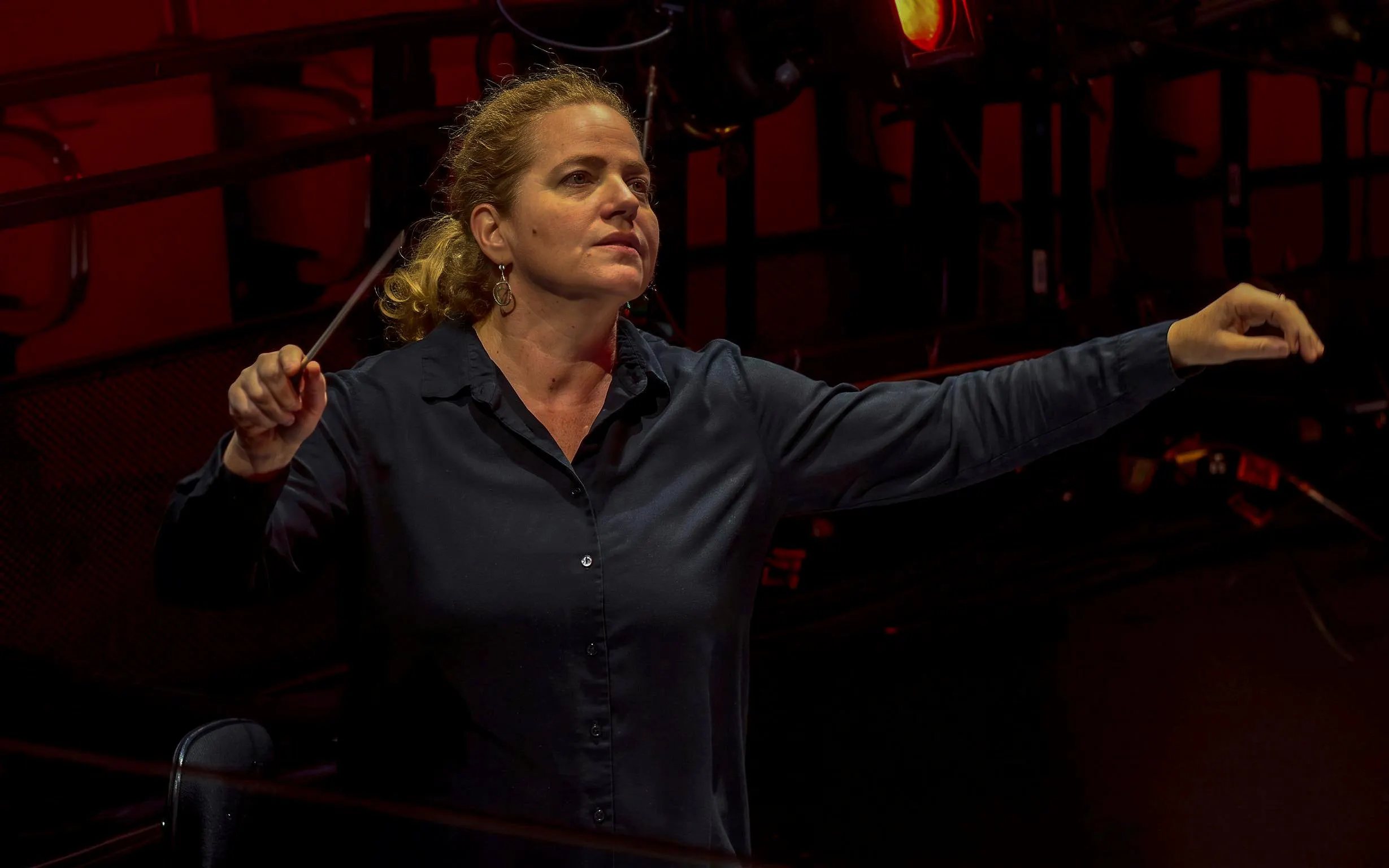 Conductor leading an orchestra for My Fair Lady performance.