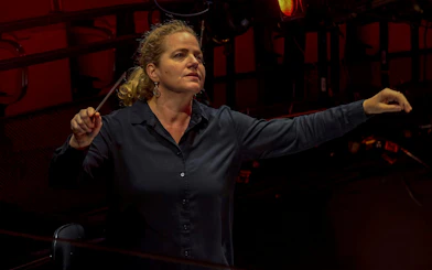 Conductor leading an orchestra for My Fair Lady performance.