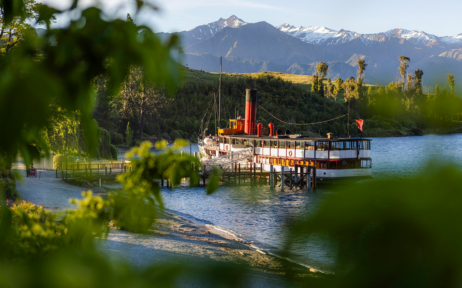 Boat anchored near Walter Peak High Country Farm with scenic mountain backdrop in New Zealand.