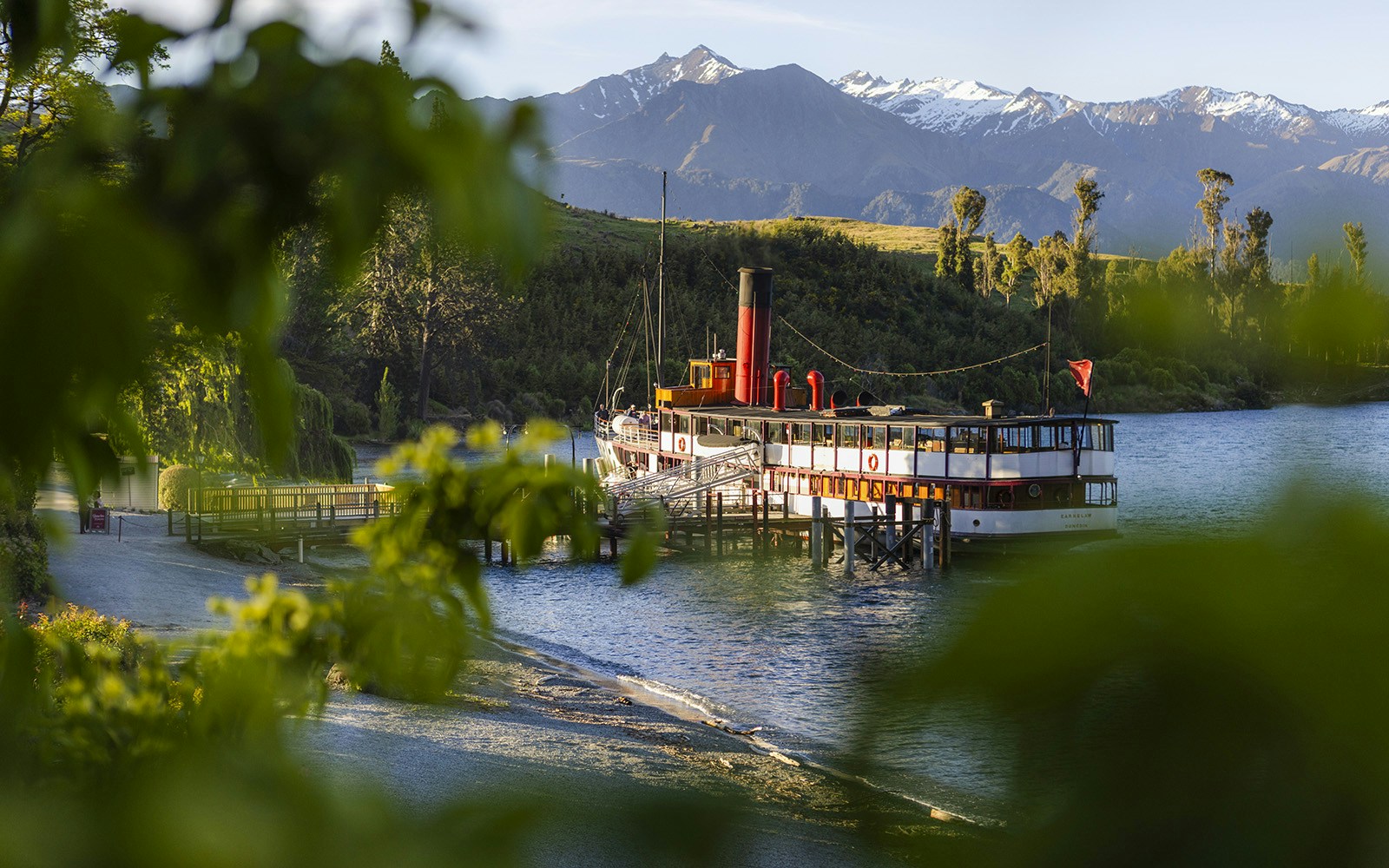 Boat anchored near Walter Peak High Country Farm with scenic mountain backdrop in New Zealand.