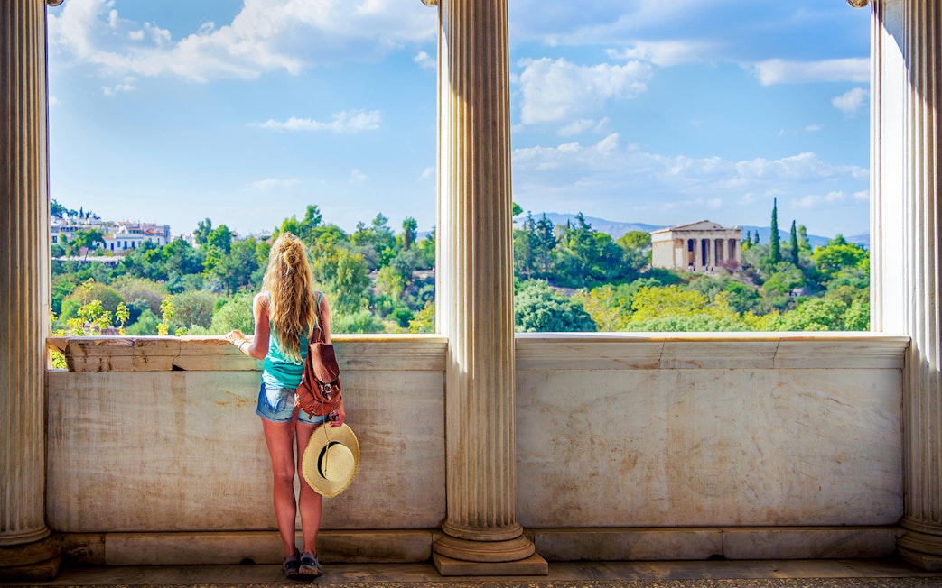 Woman viewing Ancient Agora from a marble balcony in Athens, Greece.