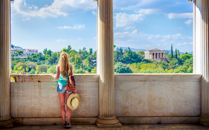 Woman viewing Ancient Agora from a marble balcony in Athens, Greece.