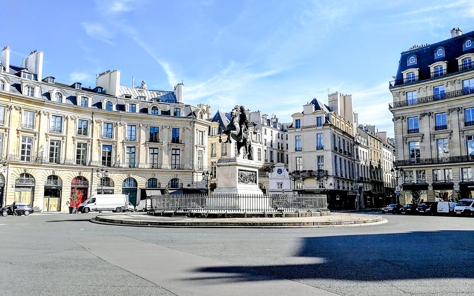 Equestrian statue at Place des Victoires in Paris surrounded by historic buildings.