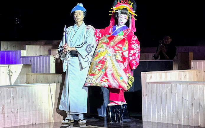 Traditional Japanese performers in colorful attire at Authentic Sumo Experience.
