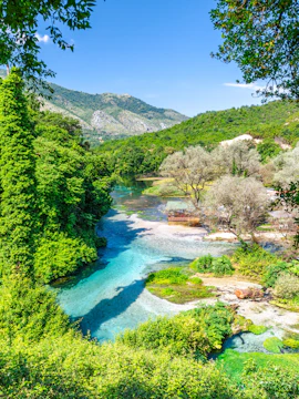 Blue Eye water spring in Albania with clear turquoise water and lush green surroundings.