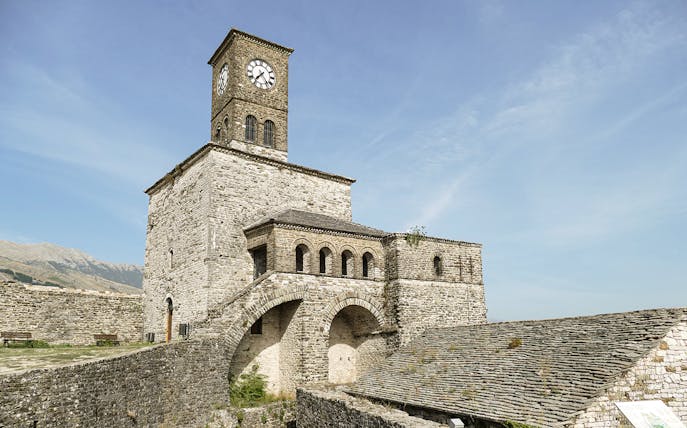 Gjirokaster Castle clock tower against a clear sky in Albania.