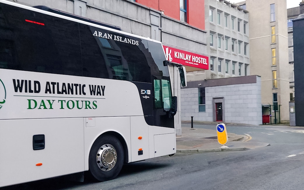 Bus parked near Kinlay Hostel for Wild Atlantic Way day tours in Galway.