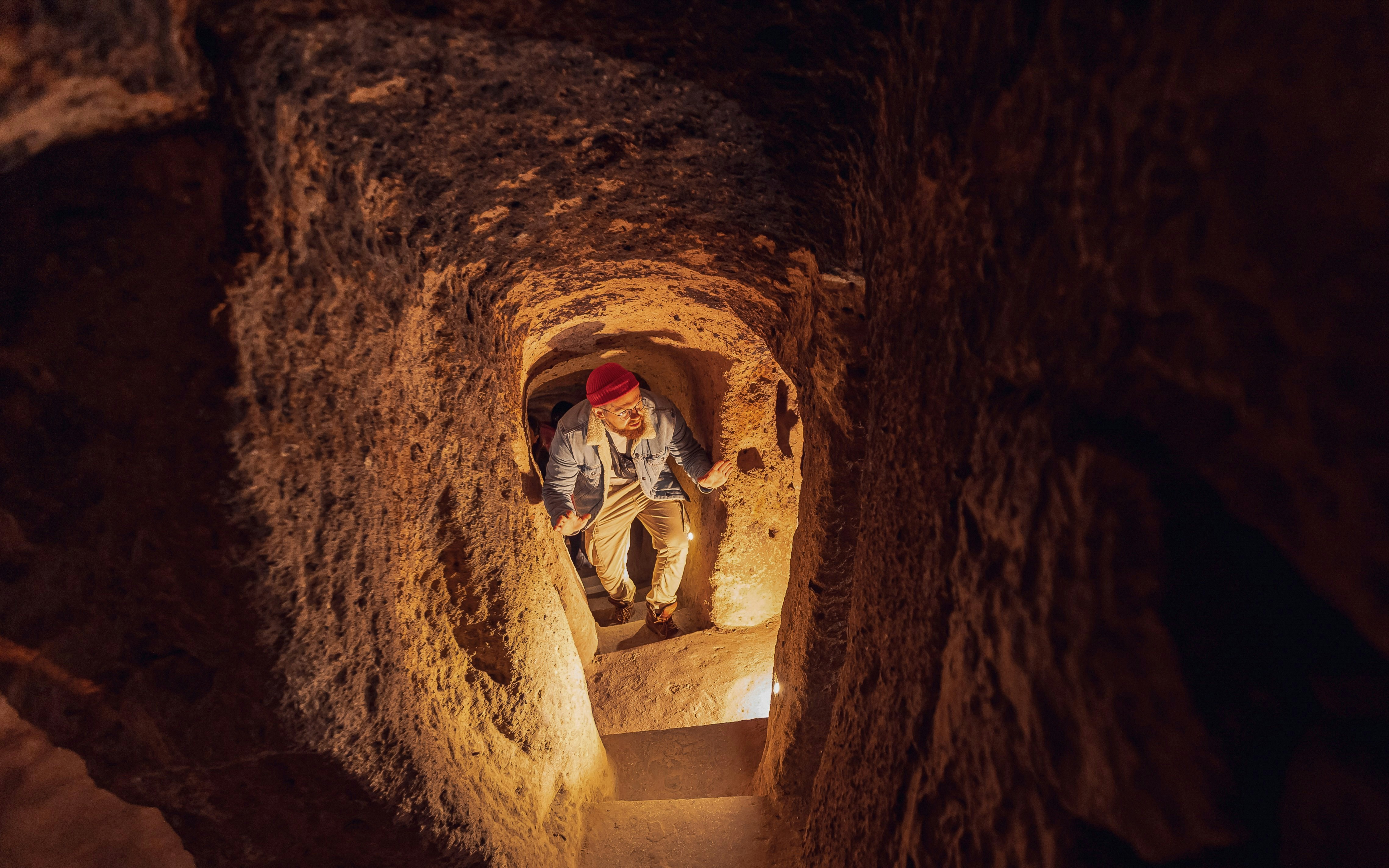 Visitor exploring narrow passage in Kaymakli Underground City, Cappadocia.