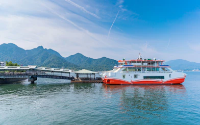 Ferry docked at Miyajima Island with mountains in the background, part of Hiroshima tour.