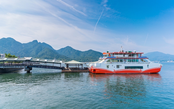 Ferry docked at Miyajima Island with mountains in the background, part of Hiroshima tour.
