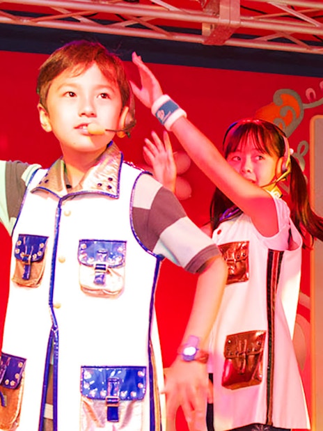 Children performing on stage at KidZania Singapore school program.