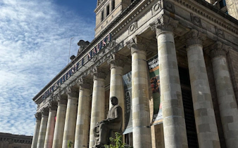 Palace of Culture and Science facade with columns and statue in Warsaw.