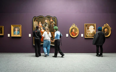 Visitors viewing classic paintings at Groeningemuseum, Bruges.