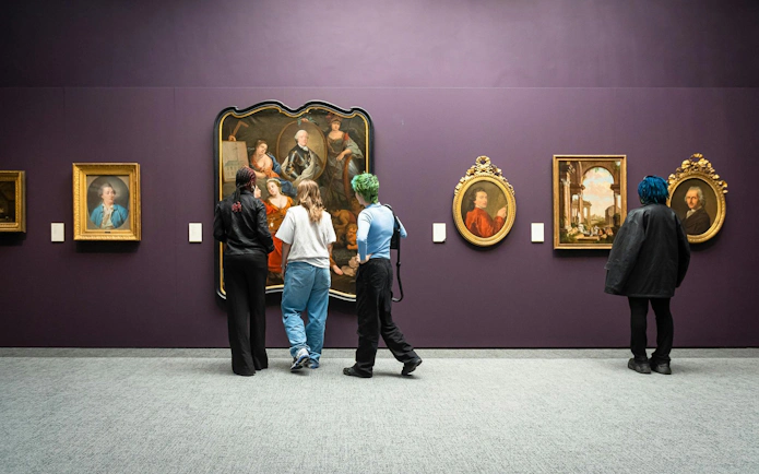Visitors viewing classic paintings at Groeningemuseum, Bruges.