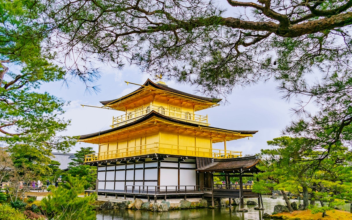 Kinkaku-ji, the Golden Pavilion, surrounded by trees and reflecting in a pond, Kyoto, Japan.