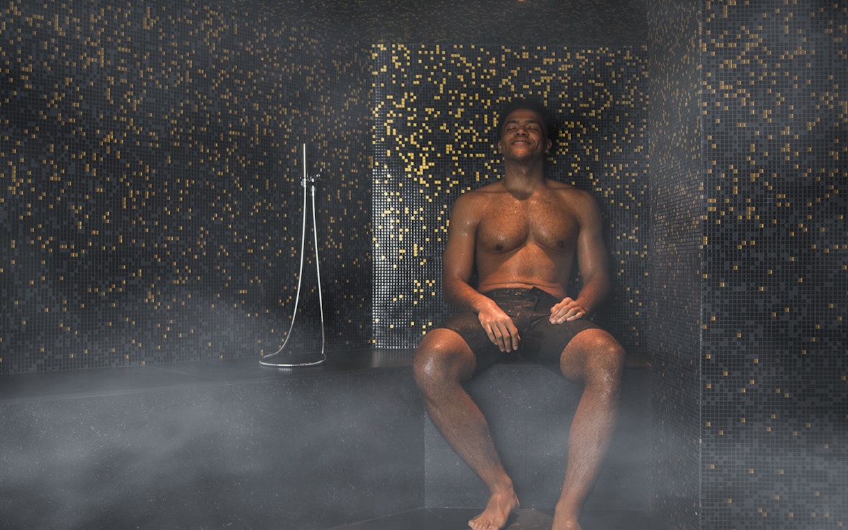 Man relaxing in a steam room at QC New York spa.