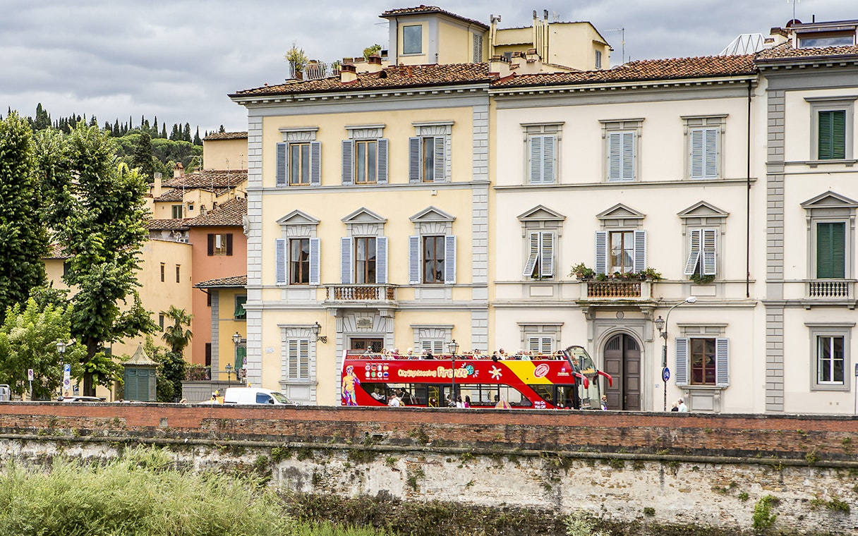 HOHO tour bus passing by historic buildings near Hotel Embassy, Florence.