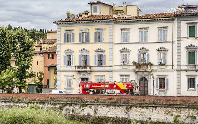 HOHO tour bus passing by historic buildings near Hotel Embassy, Florence.