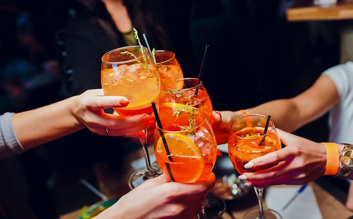 People toasting with Aperol Spritz at Illy Caffè, St. Mark's Square, Venice.