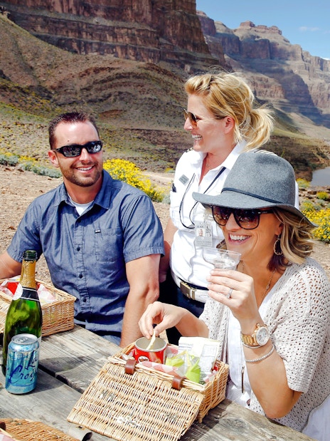 Guests enjoying snacks and champagne on the Grand Canyon floor with scenic views.