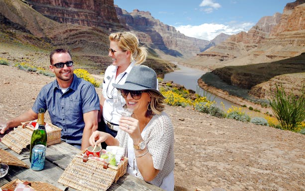 Guests enjoying snacks and champagne on the Grand Canyon floor with scenic views.