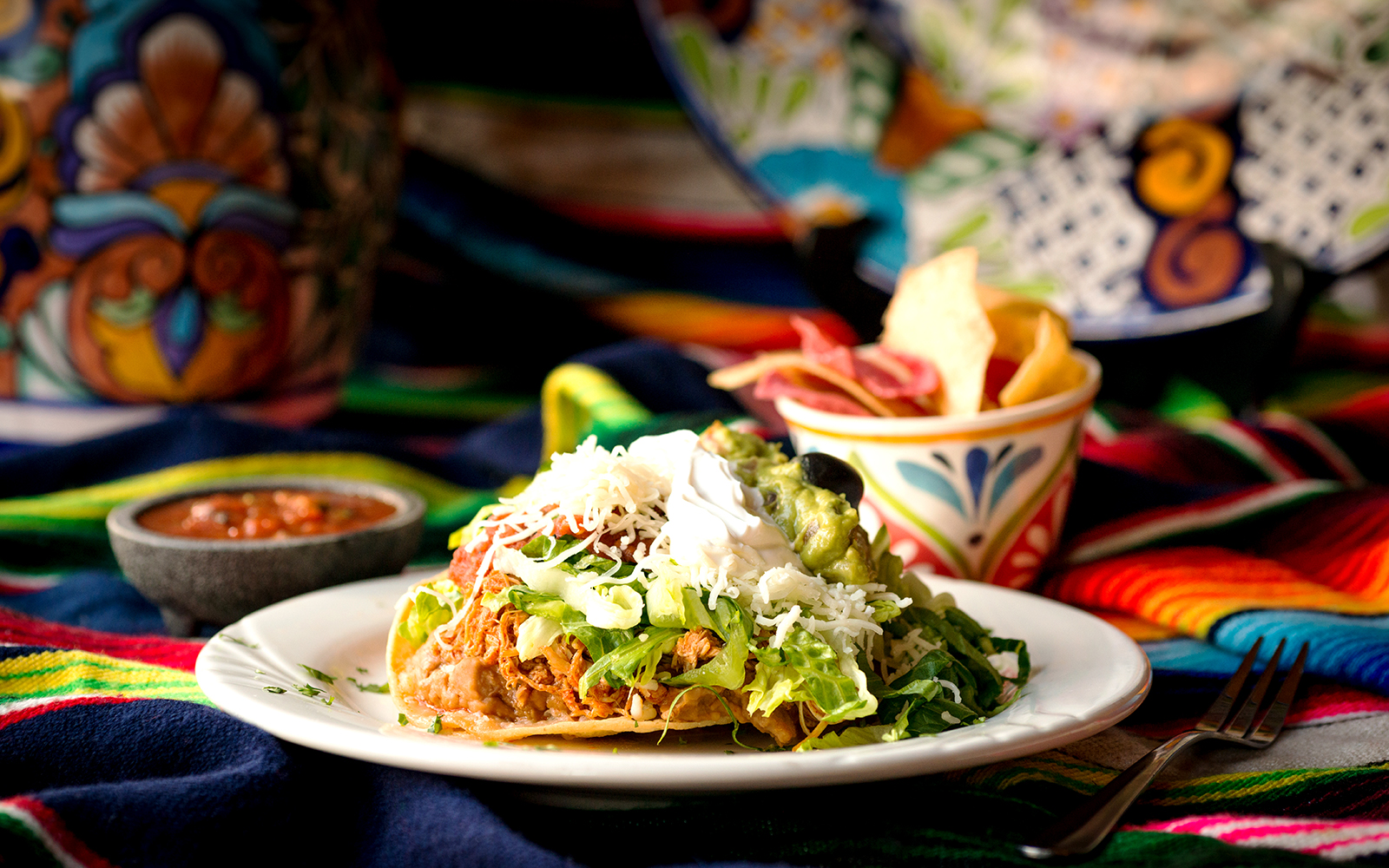 Catamaran sailing on clear waters near rocky coastline in Mallorca.
