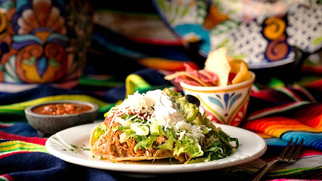 Traditional Mexican dish with shredded meat, lettuce, and guacamole on a plate, Mallorca tour.