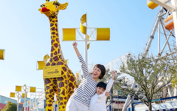 Family posing with LEGO giraffe at LEGOLAND Discovery Center Osaka.