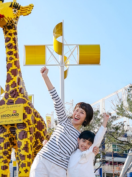 Family posing with LEGO giraffe at LEGOLAND Discovery Center Osaka.