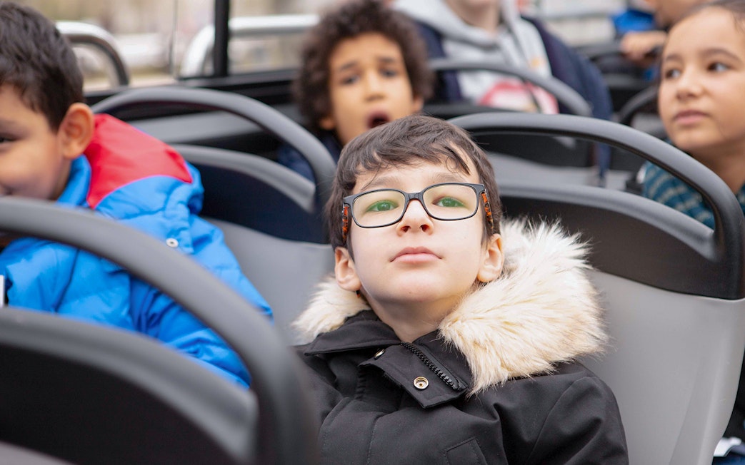 Child with glasses enjoying view on Tootbus tour in Paris.