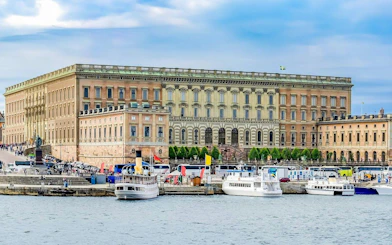 Royal Palace in Stockholm with boats docked along the waterfront.