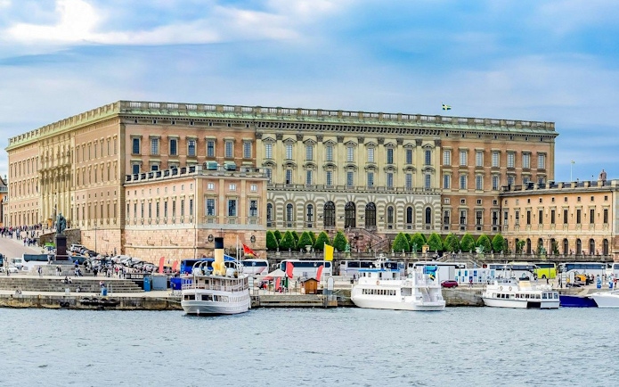 Royal Palace in Stockholm with boats docked along the waterfront.