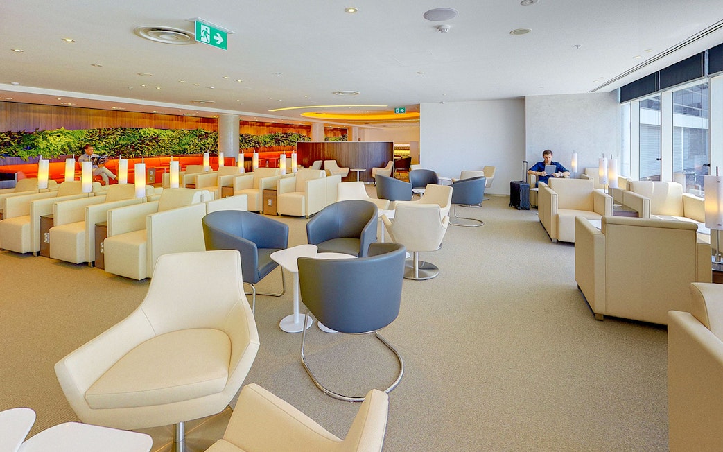 Plaza Premium Lounge seating area in International Departures with modern chairs and ambient lighting.