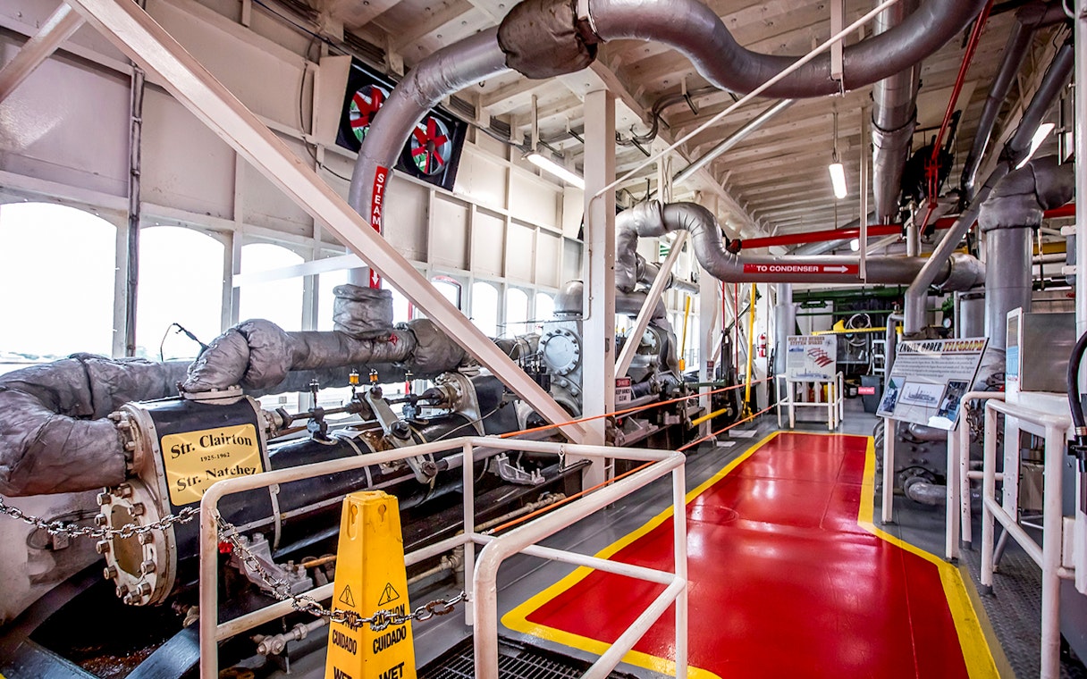 Steamboat Natchez engine room with machinery and steam pipes.