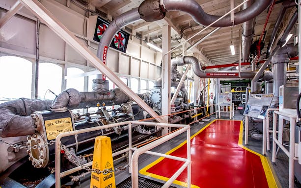 Steamboat Natchez engine room with machinery and steam pipes.