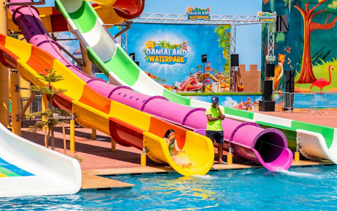 Colorful water slides at Agadir Aqua Park with a person sliding into the pool.