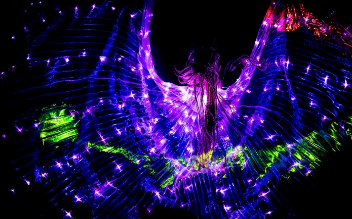 Performers in illuminated costumes at Prague black light theatre.