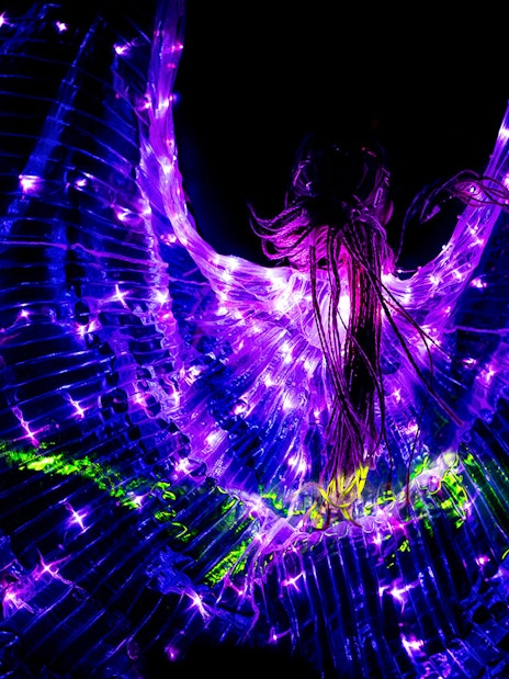 Performers in illuminated costumes at Prague black light theatre.