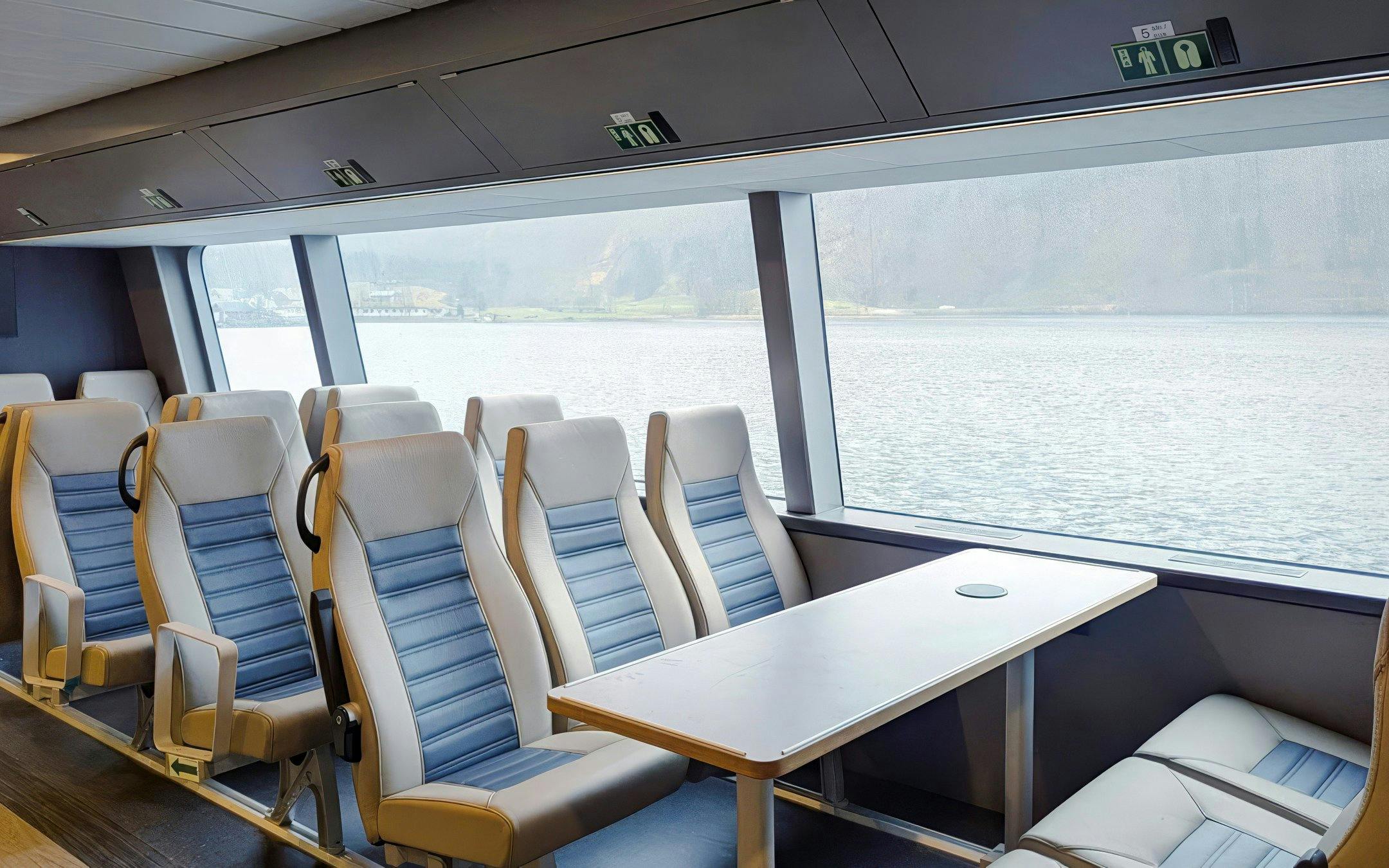 Cruise ship seating with large windows overlooking Geiranger Fjord.