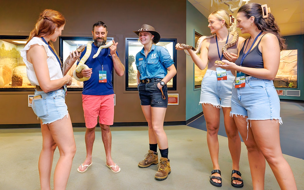 Guests holding snakes at Crocosaurus Cove exhibit.