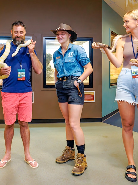 Guests holding snakes at Crocosaurus Cove exhibit.
