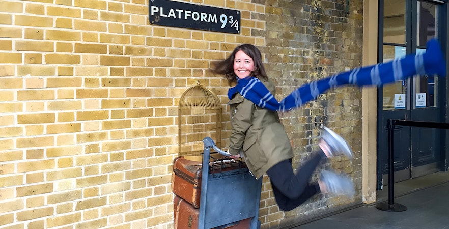 Person posing with luggage cart at Platform 9 ¾, King's Cross Station, London.