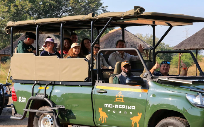 Tourists on a safari vehicle at Pilanesberg National Park.