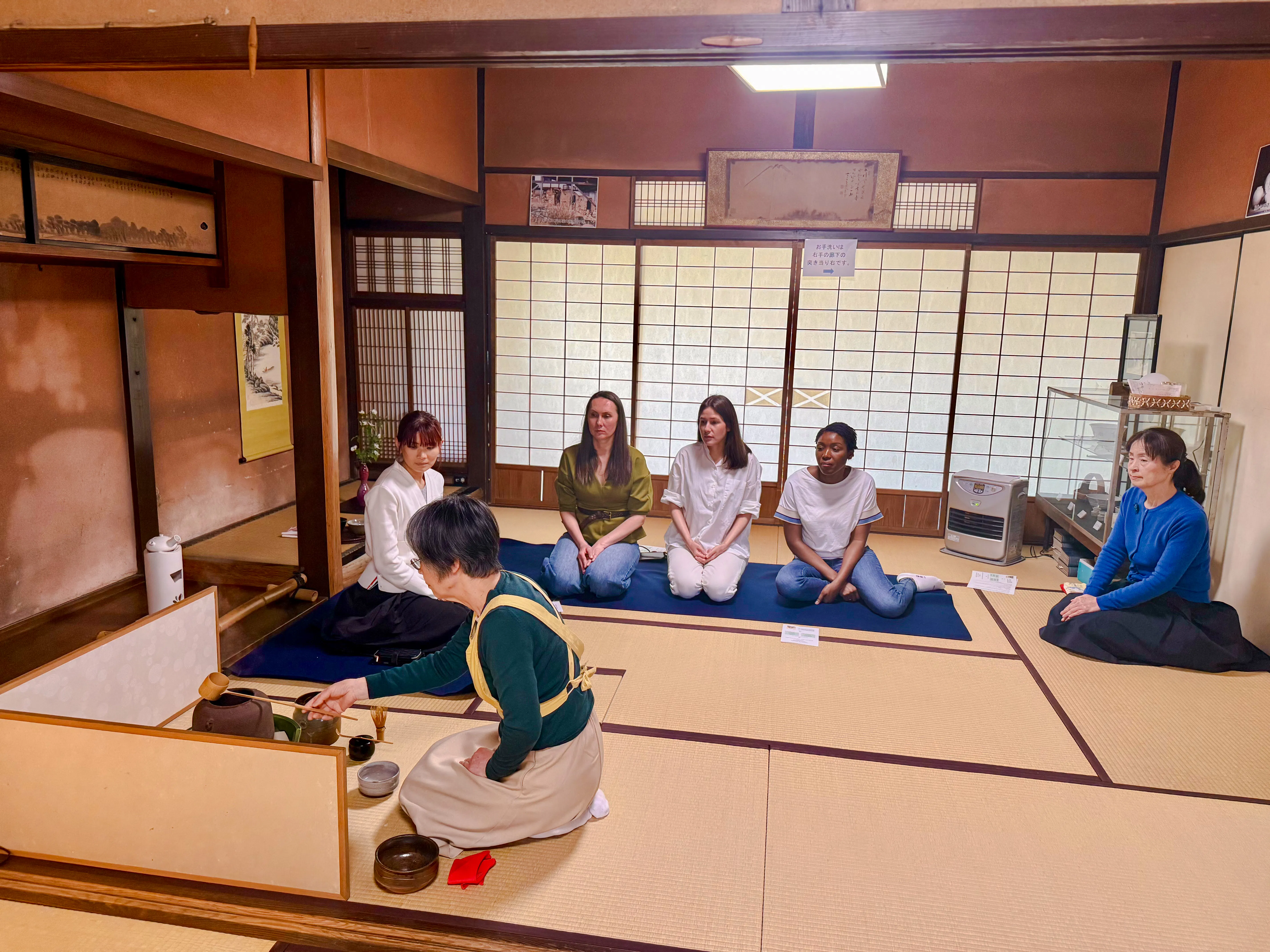 Tea ceremony participants seated in a traditional tatami room at a cultural house in Hyogo.