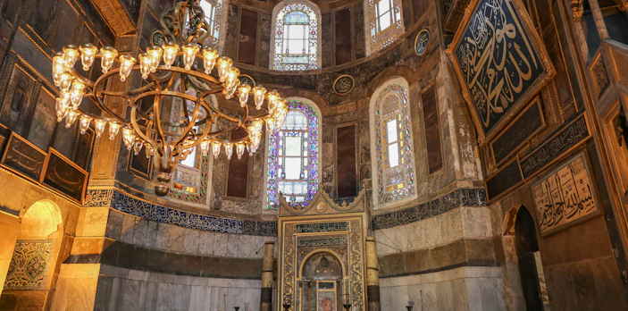 Interior of Hagia Sophia with ornate chandelier and stained glass windows, Istanbul.