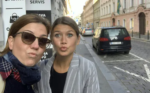Two people posing on a cobblestone street in Prague during a self-guided city exploration game.
