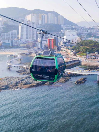 Cable car over Songdo Beach in Busan with cityscape and ocean view.