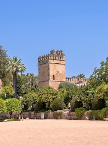 Alcazar of Cordoba tower and gardens under clear blue sky.