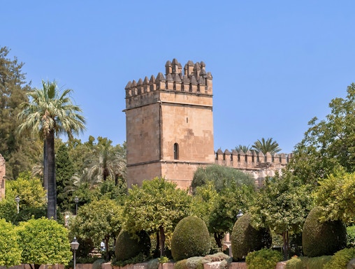 Alcazar of Cordoba tower and gardens under clear blue sky.