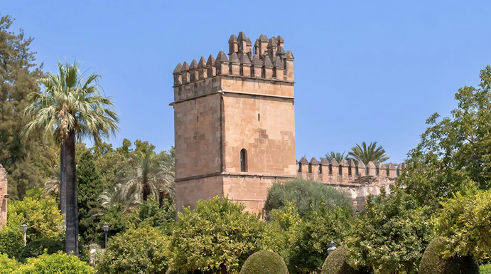 Alcazar of Cordoba tower and gardens under clear blue sky.